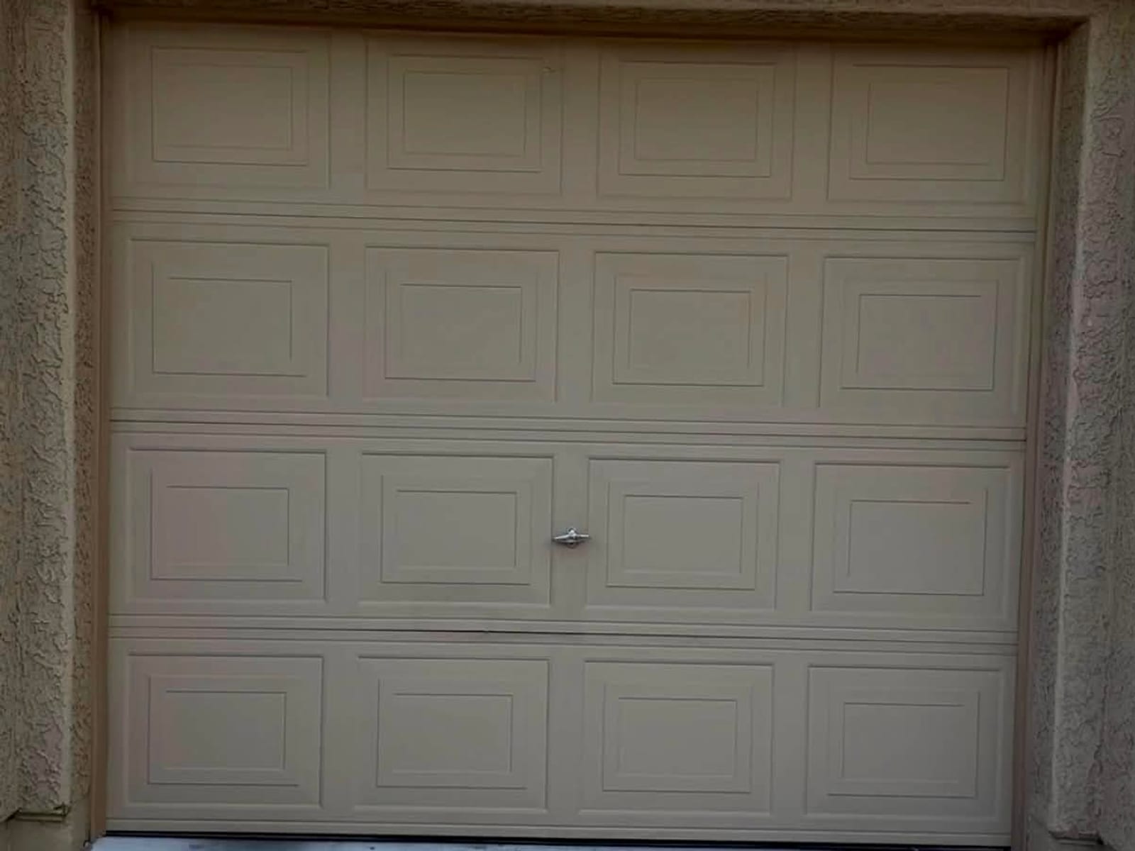 Before: dented and cracked raised-panel garage door, closed, that had not opened in years, in Mesa